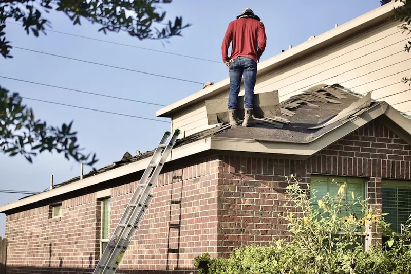 Professional roofer working on a residential roof in Montbello